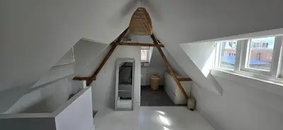 an attic hallway with a staircase and a window at Centrally located, fully furnished luxury apartment in Gouda