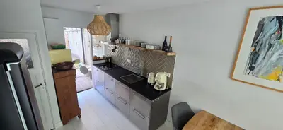 a kitchen with a black counter top and white cabinets at Centrally located, fully furnished luxury apartment in Gouda