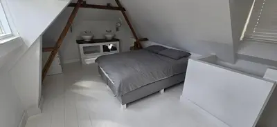 a small bedroom with a bed and a table at Centrally located, fully furnished luxury apartment in Gouda