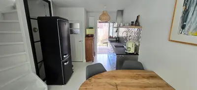 a kitchen with a table and a black refrigerator at Centrally located, fully furnished luxury apartment in Gouda