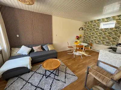a living room with a couch and a table at Bungalow at the Beach in Noordwijk aan Zee