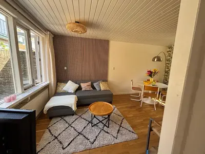 a living room with a couch and a table at Bungalow at the Beach in Noordwijk aan Zee