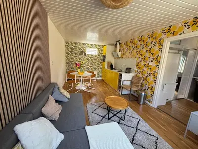 a living room with a couch and a table at Bungalow at the Beach in Noordwijk aan Zee