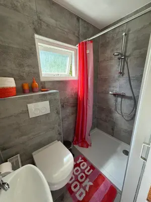 a bathroom with a shower and a toilet and a sink at Bungalow at the Beach in Noordwijk aan Zee