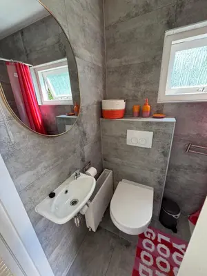 a bathroom with a sink and a toilet and a mirror at Bungalow at the Beach in Noordwijk aan Zee