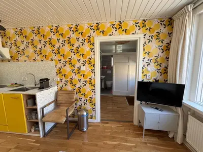 a kitchen with yellow and white flowers on the wall at Bungalow at the Beach in Noordwijk aan Zee