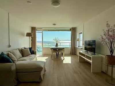 a living room with a couch and a table with a television at Sunset Beach in Zandvoort