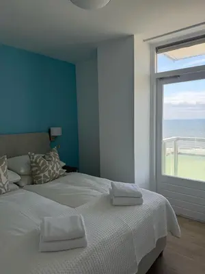 a bedroom with a large bed with a large window at Sunset Beach in Zandvoort