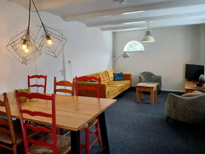 a living room with a table and a couch at Vakantiewoning De 