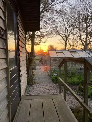 a porch of a house with a bench and a greenhouse at De Verborgen Pracht in Schagen