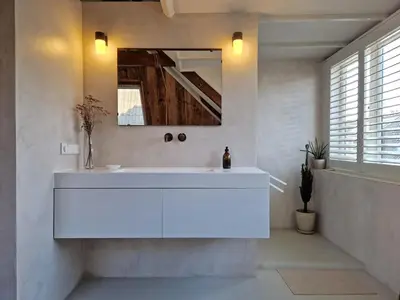 a white bathroom with a sink and a mirror at Loft with parkside view in Amsterdam