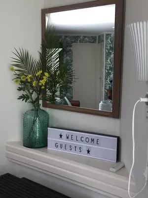 a mirror on a shelf with a welcome guest sign at Landelijk gelegen chalet aan de Vecht vlakbij Amsterdam in Nigtevecht