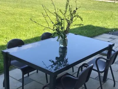 a blue table with a vase of flowers on it at Landelijk gelegen chalet aan de Vecht vlakbij Amsterdam in Nigtevecht