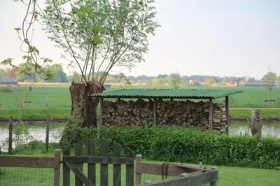 a wooden bench in front of a building with a green roof at Landelijk gelegen chalet aan de Vecht vlakbij Amsterdam in Nigtevecht
