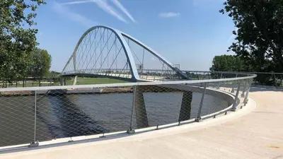 a bridge over a river next to a body of water at Landelijk gelegen chalet aan de Vecht vlakbij Amsterdam in Nigtevecht