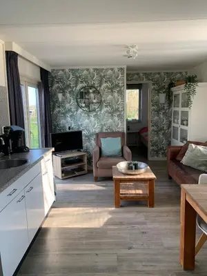a living room with a couch and a table at Landelijk gelegen chalet aan de Vecht vlakbij Amsterdam in Nigtevecht