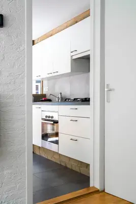 a kitchen with white cabinets and a sink at -Duna Lago- nabij het meer, restaurants en Keukenhof in Noordwijkerhout