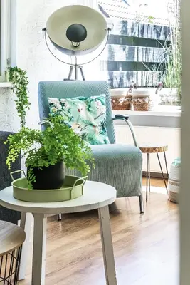a living room with a blue chair and a table with a plant at -Duna Lago- nabij het meer, restaurants en Keukenhof in Noordwijkerhout