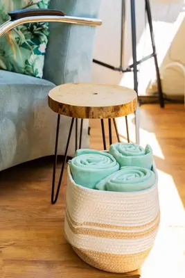 a side table with a stool on the floor next to a couch at -Duna Lago- nabij het meer, restaurants en Keukenhof in Noordwijkerhout