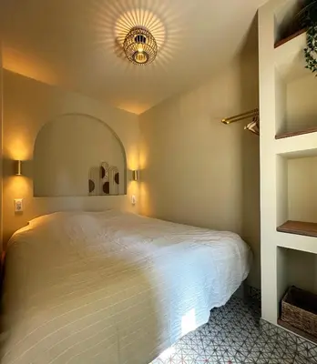 a bedroom with a large white bed with a ceiling at Beach Hide-out Zandvoort in Zandvoort