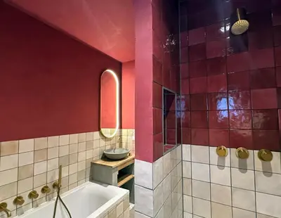 a bathroom with red walls and a tub and a sink at Beach Hide-out Zandvoort in Zandvoort