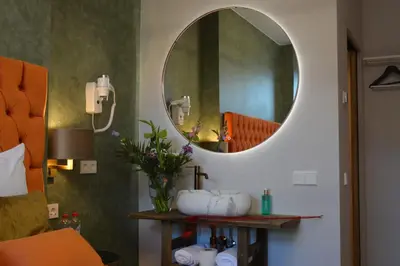 a bathroom with a round mirror on the wall at The IF Boutique hotel in Amsterdam