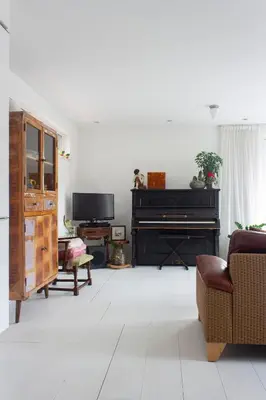 a living room with a piano and a couch at Lovely cozy houseboat Rembrandt, old centre Leiden in Leiden