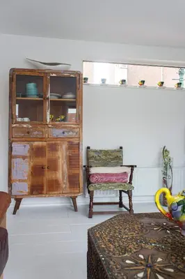 a living room with a dresser and a chair at Lovely cozy houseboat Rembrandt, old centre Leiden in Leiden