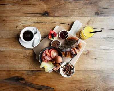 a table with a plate of breakfast foods and a cup of coffee at Amsterdam Teleport Hotel - Free Parking in Amsterdam
