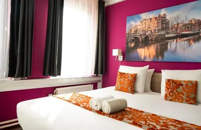 a bedroom with a king sized bed with purple walls at Amsterdam Teleport Hotel - Free Parking in Amsterdam