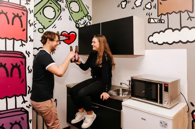 a man and a woman taking a picture in a kitchen at Amsterdam Teleport Hotel - Free Parking in Amsterdam