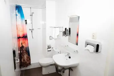 a white bathroom with a sink and a toilet at Amsterdam Teleport Hotel - Free Parking in Amsterdam
