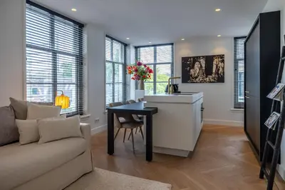a kitchen and living room with a couch and a table at De Lindekamer in Loenen aan de Vecht