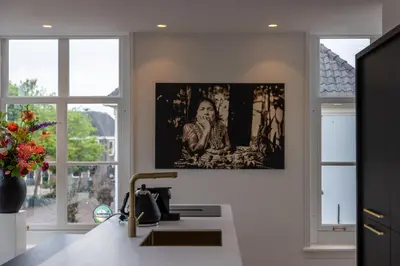 a kitchen with a painting hanging on the wall at De Lindekamer in Loenen aan de Vecht