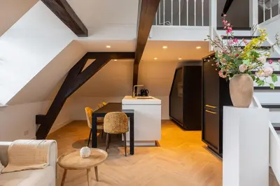a kitchen and living room with a table and chairs at De Kroonkamer in Loenen aan de Vecht