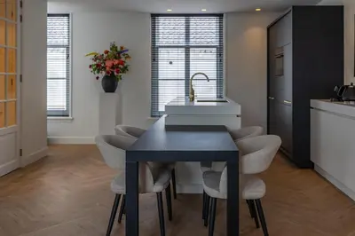 a kitchen with a sink and a table with chairs at De Buitenplaats in Loenen aan de Vecht