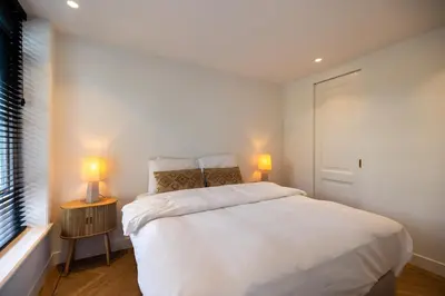 a bedroom with a large white bed and two lamps at De Buitenplaats in Loenen aan de Vecht