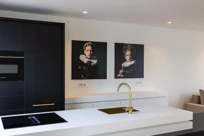 a kitchen with three portraits on the wall at De Buitenplaats in Loenen aan de Vecht