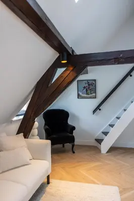a living room with a black chair and stairs at Maison Hans in Loenen aan de Vecht