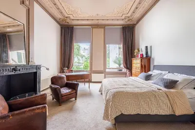 a bedroom with a bed and a fireplace and a chair at Beautiful & Well-located Canal Apartment in Amsterdam
