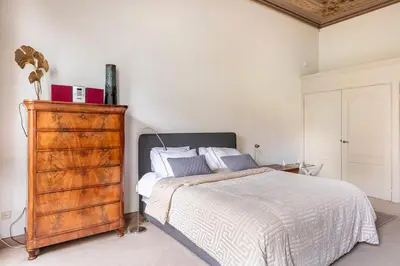 a bedroom with a bed and a wooden dresser at Beautiful & Well-located Canal Apartment in Amsterdam