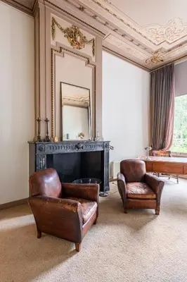 a living room with two chairs and a fireplace at Beautiful & Well-located Canal Apartment in Amsterdam