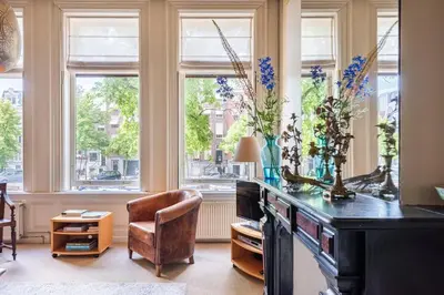 a home office with a desk and a chair and windows at Beautiful & Well-located Canal Apartment in Amsterdam