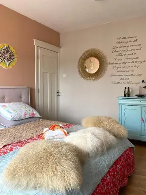 a bedroom with a bed with furry pillows on it at Bubbles & Bed in Bilthoven