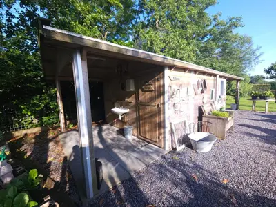 a small shed with a toilet in a yard at Trekkershut - De Hollandse Boerderij in Ons Belang