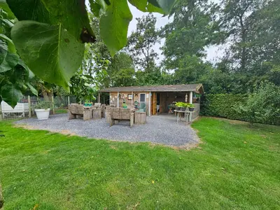 a patio with a table and chairs in a yard at Trekkershut - De Hollandse Boerderij in Ons Belang