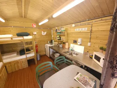 a kitchen with a counter and chairs in a cabin at Trekkershut - De Hollandse Boerderij in Ons Belang