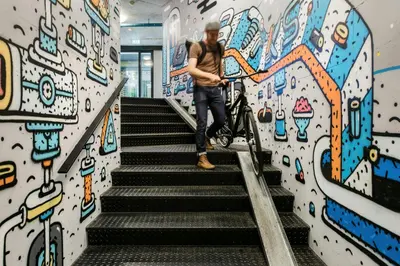 a man walking a bike down the stairs at The Social Hub Amsterdam West Extended Stay in Amsterdam