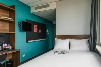 a bedroom with a bed with a blue wall at The Social Hub Amsterdam West Extended Stay in Amsterdam