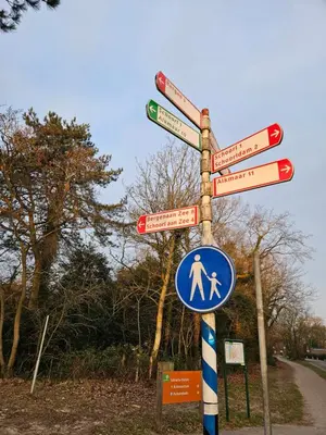 a street sign with many signs on a pole at Bed and Beach in Schoorl in Schoorl